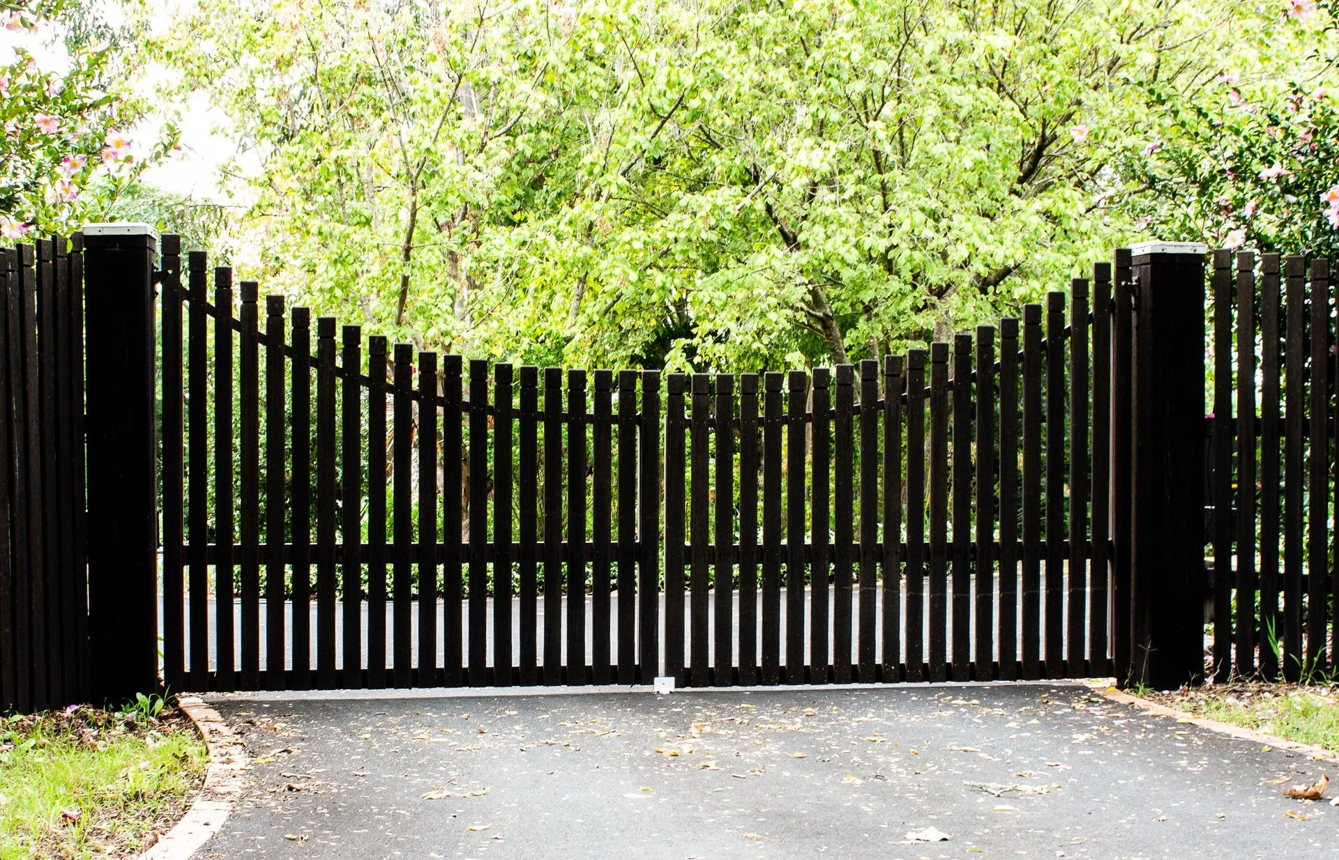 Custom black wooden arched driveway gate installed by River City Fence in Chattanooga